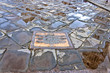 Unesco plate in Pisa and leaning tower reflected on wet floor