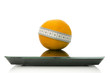 Orange wrapped with measuring tape on a scale