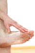 Foto: A woman putting cream on her foot A woman putting cream on her foot