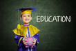 Foto: Happy boy with scholar gown and piggy bank Happy boy with scholar gown and piggy bank