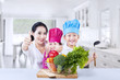 Photo: Happy family chef and vegetable at home Happy family chef and vegetable at home