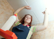 Woman glues ceiling tile