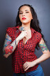 Photo of beautiful girl with tattoos and tattoo machine..
