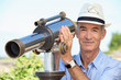 Photo: Senior man watching landscape with spyglass Senior man watching landscape with spyglass