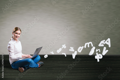 Photo: young girl sitting on the floor with a laptop young girl sitting on the floor with a laptop