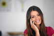 Foto: Chirpy brunette using her mobile telephone Chirpy brunette using her mobile telephone