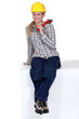 Tradeswoman sitting on a block and holding a pipe wrench