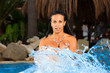 Young beautiful woman splashing water