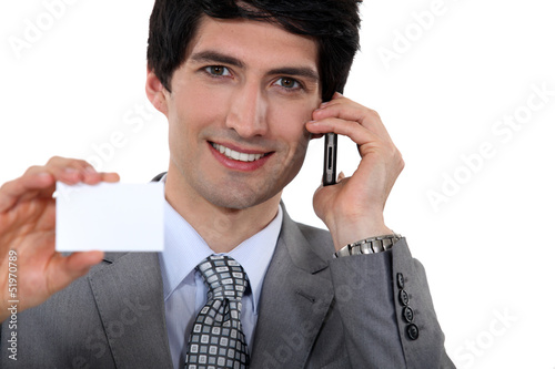 Photo: Executive holding a blank business card Executive holding a blank business card