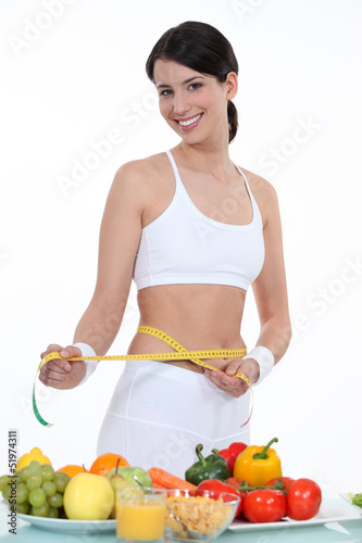 Photo: Sporty woman measuring waist Sporty woman measuring waist