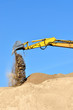 new yellow excavator working on sand dunes. Scoop close-up