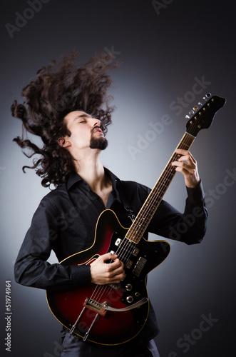 Photo: Man playing guitar during concert Man playing guitar during concert