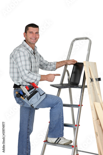 Photo: Builder with wood and a laptop Builder with wood and a laptop