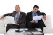 Photo: Two executives sitting on white sofa Two executives sitting on white sofa