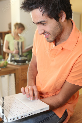 Photo: woman cooking and man with computer woman cooking and man with computer