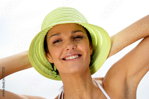 Photo: Brunette in hat relaxing at the beach Brunette in hat relaxing at the beach