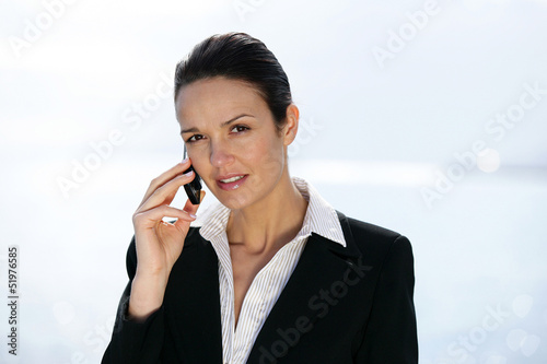 Photo: Businesswoman outdoors on a cellphone Businesswoman outdoors on a cellphone