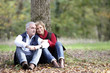 Photo: Couple sat by tree Couple sat by tree