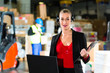 Woman using headset and laptop at warehouse