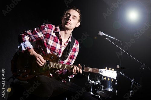 Photo: Man playing guitar during concert Man playing guitar during concert