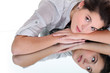 Foto: Young woman resting her head on a mirrored surface Young woman resting her head on a mirrored surface