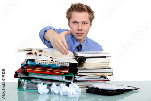 Photo: man giving his hand over a pile of folders man giving his hand over a pile of folders