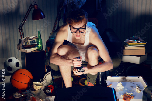 Photo: Gamer nerd playing video games on television Gamer nerd playing video games on television