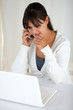 Pensive young woman reading on laptop screen