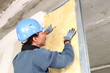 Man fitting wall insulation