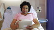 Senior Female Patient In Hospital Bed With Digital Tablet