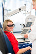 Optometry concept - pretty young woman having her eyes examined