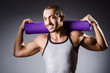 Muscular Man With Mat In Studio