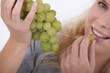 Foto: Attractive blond woman eating bunch of grapes Attractive blond woman eating bunch of grapes