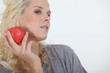 Foto: Attractive blond holding red apple Attractive blond holding red apple