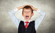 Surprised little businessman on irregular gray wall