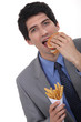 Businessman eating burger and fries