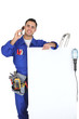 Photo: Electrician with a telephone and a board for message Electrician with a telephone and a board for message