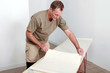 Foto: Man laying wallpaper Man laying wallpaper