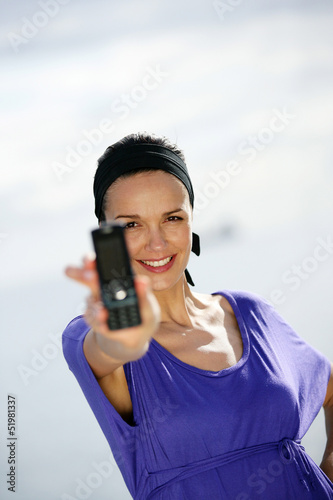 Photo: Woman with a cellphone at the beach Woman with a cellphone at the beach
