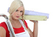 Photo: Very pretty young woman preparing to wallpaper a room Very pretty young woman preparing to wallpaper a room