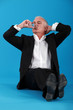 Senior business sat on the floor with champagne flute