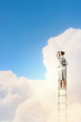 Photo: Businesswoman standing on ladder Businesswoman standing on ladder