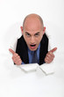 Man peeking through torn paper hole