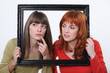 girls behind a wooden frame