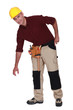 Tradesman bending over to pick something up