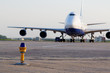 Big jetplane parked at airport, focus on ground lamp at taxiway