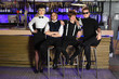 Four glamorous rock band pose near bar counter
