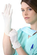 Photo: Female medic in scrubs pulling on a rubber glove Female medic in scrubs pulling on a rubber glove