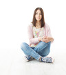 Foto: Beautiful girl teenager sitting on floor. White background Beautiful girl teenager sitting on floor. White background