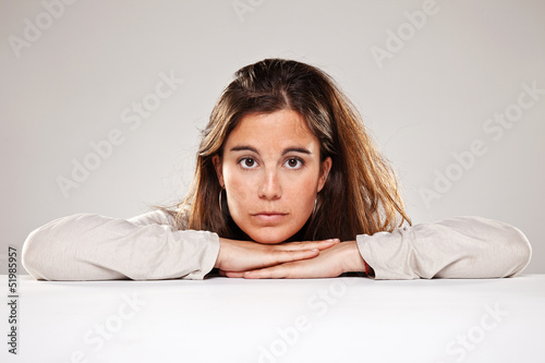 Photo: Portrait of a Pretty young woman leaning on a table Portrait of a Pretty young woman leaning on a table